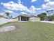 View of the home's backyard, including the screened-in porch and white fence at 4644 Braesgate Ct, Land O Lakes, FL 34639
