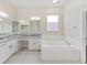 Elegant bathroom featuring a large vanity with double sinks, a soaking tub, and plenty of natural light at 4644 Braesgate Ct, Land O Lakes, FL 34639