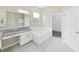 Luxurious bathroom boasts double sink vanity, soaking tub, walk-in closet, and pristine white tile flooring at 4644 Braesgate Ct, Land O Lakes, FL 34639