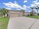 Lovely home featuring a three car garage and a well-manicured lawn and landscaping at 4644 Braesgate Ct, Land O Lakes, FL 34639