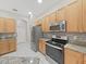 Well-lit kitchen boasting stainless steel appliances, granite countertops, and light wood cabinetry at 4644 Braesgate Ct, Land O Lakes, FL 34639