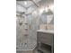 Bathroom featuring glass enclosed shower with marble-style tile and vanity with storage at 5075 Starfish Se Dr # B, St Petersburg, FL 33705