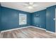 Bedroom with a modern ceiling fan, window for natural light, and gray wood floors at 5075 Starfish Se Dr # B, St Petersburg, FL 33705