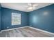 Bedroom with wood-look flooring, ceiling fan and window views at 5075 Starfish Se Dr # B, St Petersburg, FL 33705