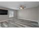 Bedroom featuring wood laminate flooring, ceiling fan, and a large window at 5075 Starfish Se Dr # B, St Petersburg, FL 33705