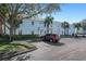 Exterior of condo building showcasing assigned parking spaces, palm trees, and a neatly landscaped community at 5075 Starfish Se Dr # B, St Petersburg, FL 33705