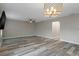 Living room featuring wood laminate flooring, ceiling fan, and modern light fixture at 5075 Starfish Se Dr # B, St Petersburg, FL 33705