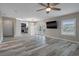 Spacious living room featuring modern flooring, a ceiling fan, and a large window allowing for plenty of natural light at 5075 Starfish Se Dr # B, St Petersburg, FL 33705