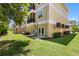 Backyard of condo building with a manicured lawn and private patios at 5089 Royal Palms Way # 202, New Port Richey, FL 34652