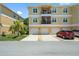 Multi-story condo building with private garages, balconies, and tidy landscaping at 5089 Royal Palms Way # 202, New Port Richey, FL 34652