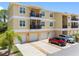 Spacious condo building featuring private garages, balconies, and manicured landscaping, enhancing curb appeal at 5089 Royal Palms Way # 202, New Port Richey, FL 34652