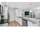 Bright kitchen features an island with granite countertops, stainless steel appliances, and wood flooring at 5089 Royal Palms Way # 202, New Port Richey, FL 34652