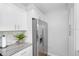 Modern kitchen showcasing stainless steel refrigerator, sleek white cabinets, and stylish backsplash, blending style with functionality at 5089 Royal Palms Way # 202, New Port Richey, FL 34652