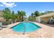 Community pool with seating, landscaping, and view of the clubhouse at 5089 Royal Palms Way # 202, New Port Richey, FL 34652