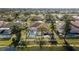 An aerial view of a home with a screened pool, patio, and lush landscaping facing a lake at 5117 Spectacular Bid Dr, Wesley Chapel, FL 33544