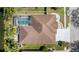 An aerial view of a backyard oasis featuring a screened pool, spa, patio, and lush landscaping at 5117 Spectacular Bid Dr, Wesley Chapel, FL 33544