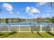 Picturesque backyard view of a serene lake behind a white picket fence at 5117 Spectacular Bid Dr, Wesley Chapel, FL 33544