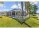 A sprawling backyard with screened pool, patio, tropical landscaping, and views of the lake at 5117 Spectacular Bid Dr, Wesley Chapel, FL 33544