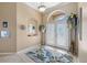 Inviting foyer with decorative glass doors, arched window and decorative rug at 5117 Spectacular Bid Dr, Wesley Chapel, FL 33544