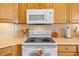 Close-up of the kitchen featuring an electric stove, microwave, and ample counter space at 5117 Spectacular Bid Dr, Wesley Chapel, FL 33544