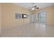 Living room with a ceiling fan, tile flooring, and sliding door access to the pool at 5117 Spectacular Bid Dr, Wesley Chapel, FL 33544