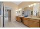 Bright main bathroom with a double vanity, tiled floor, and natural light at 5117 Spectacular Bid Dr, Wesley Chapel, FL 33544