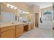 Main bathroom features double vanity, large mirror, soaking tub and decorative window at 5117 Spectacular Bid Dr, Wesley Chapel, FL 33544