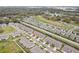 Panoramic aerial view of a sprawling residential community with rows of homes, green spaces, and a golf course in the distance at 6850 Ripple Pond Loop, Zephyrhills, FL 33541
