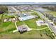 Beautiful aerial view of a community featuring a playground, pool, and many homes surrounding a pond at 6850 Ripple Pond Loop, Zephyrhills, FL 33541
