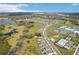 Wide aerial view capturing community near winding roads, scenic lakes, and recreational amenities like tennis courts and a pool at 6850 Ripple Pond Loop, Zephyrhills, FL 33541
