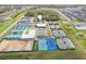 Aerial shot of multiple tennis courts with blue and green surfaces near a clubhouse at 6850 Ripple Pond Loop, Zephyrhills, FL 33541