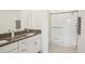 Elegant bathroom with a double sink vanity, granite countertop, and a glass-enclosed shower, creating a luxurious feel at 6850 Ripple Pond Loop, Zephyrhills, FL 33541