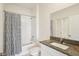 Well-lit bathroom featuring a vanity with granite countertop, toilet, and tub with shower and curtain at 6850 Ripple Pond Loop, Zephyrhills, FL 33541