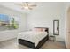 Well-lit bedroom features a large window with an upholstered bed and a side table at 6850 Ripple Pond Loop, Zephyrhills, FL 33541