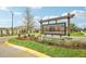 Welcoming Abbott Square community entrance featuring stone accents and lush landscaping at 6850 Ripple Pond Loop, Zephyrhills, FL 33541
