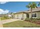 Inviting townhome exterior with attached garage, well-maintained lawn, and tropical landscaping at 6850 Ripple Pond Loop, Zephyrhills, FL 33541