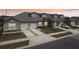 Charming townhome exterior featuring a two-car garage, well-maintained lawn and beautiful landscaping at 6850 Ripple Pond Loop, Zephyrhills, FL 33541