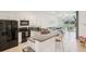 Bright kitchen featuring white cabinets, granite countertops, and modern black appliances, seamlessly connecting to the living area at 6850 Ripple Pond Loop, Zephyrhills, FL 33541