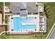 Stunning aerial view of a community pool, lounge chairs, tropical landscaping, and patio seating at 6850 Ripple Pond Loop, Zephyrhills, FL 33541