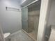 Bathroom featuring a tiled shower with glass doors and neutral-colored walls, with a towel rack at 700 Starkey Rd # 1525, Largo, FL 33771