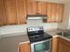 Compact kitchen boasts stainless steel appliances, wood cabinets, and durable countertops at 700 Starkey Rd # 1525, Largo, FL 33771