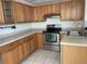 Charming kitchen featuring tile floors, abundant wood cabinetry, and stainless steel appliances at 700 Starkey Rd # 1525, Largo, FL 33771