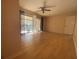 Living room featuring tan walls, ceiling fan, and a sliding glass door leading to a screened in balcony at 700 Starkey Rd # 1525, Largo, FL 33771