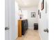 Laundry room featuring a stacked washer and dryer, storage cabinets, and decorative artwork at 707 W Ohio Ave, Tampa, FL 33603