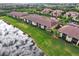 Community homes with manicured lawns backing onto a peaceful lake, seen from an aerial perspective at 7305 River Hammock Dr # 204, Bradenton, FL 34212
