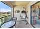 Relax on this peaceful balcony featuring a hanging chair, table, and scenic lake view for ultimate relaxation at 7305 River Hammock Dr # 204, Bradenton, FL 34212
