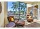 Relax on this serene balcony featuring comfortable seating with views of lush palm trees and the neighborhood at 7305 River Hammock Dr # 204, Bradenton, FL 34212