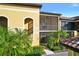 Beautiful condo building featuring convenient stairwell access, screened balconies, and tropical landscaping at 7305 River Hammock Dr # 204, Bradenton, FL 34212