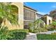 Beautiful condominium exterior featuring screened in porch with a lush landscaped walkway at 7305 River Hammock Dr # 204, Bradenton, FL 34212