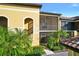 Beautiful condo building featuring convenient stairwell access, screened balconies, and tropical landscaping at 7305 River Hammock Dr # 204, Bradenton, FL 34212